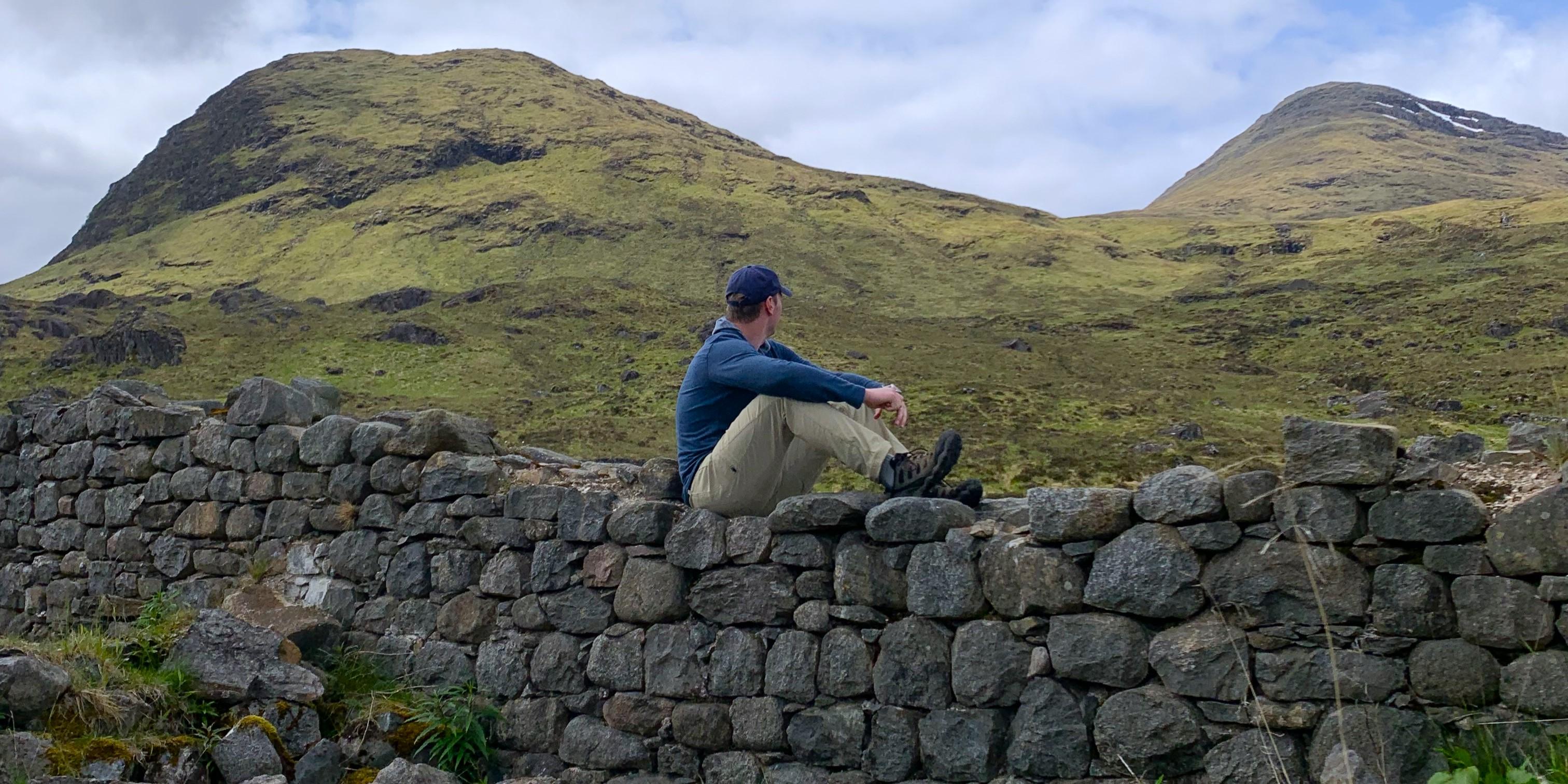 Keenan sitting on a wall in Scotland